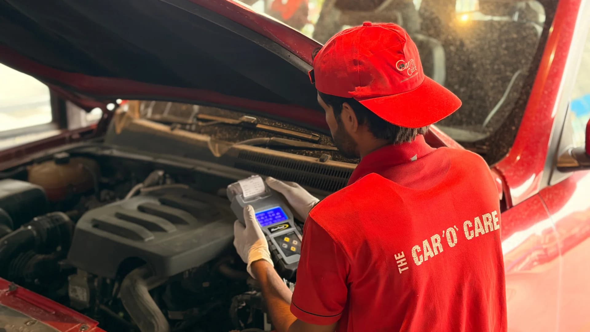 Technician performing electrical diagnostics with scanner under the bonnet