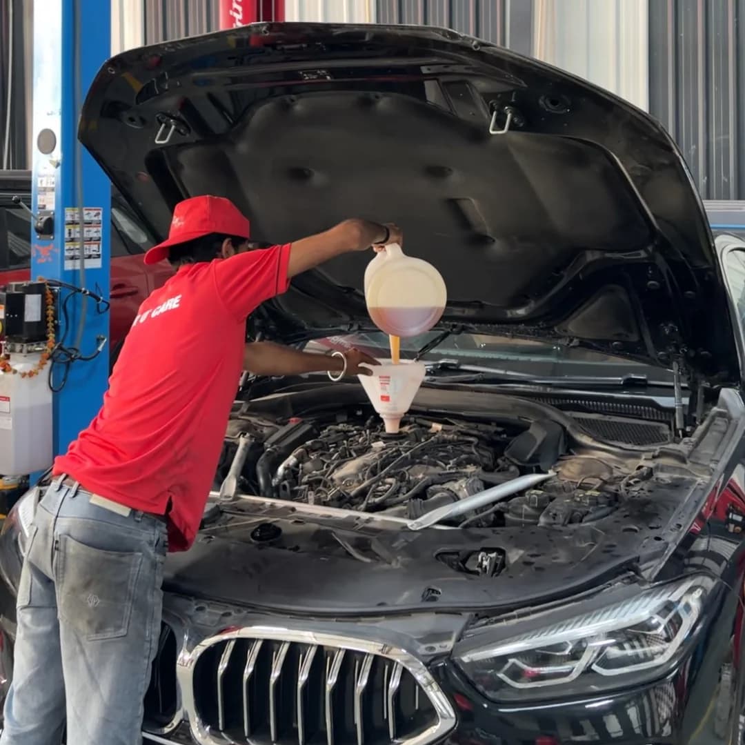 Technician performing periodic maintenance on a BMW engine in Noida