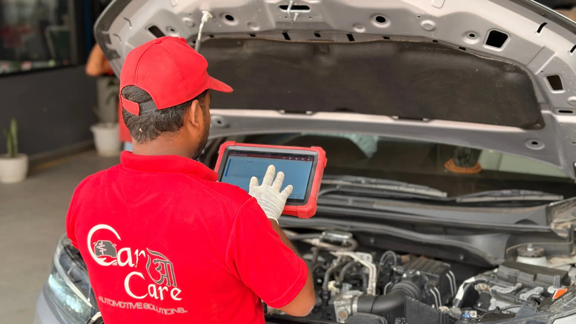 Technician performing engine diagnostics with laptop and scanner